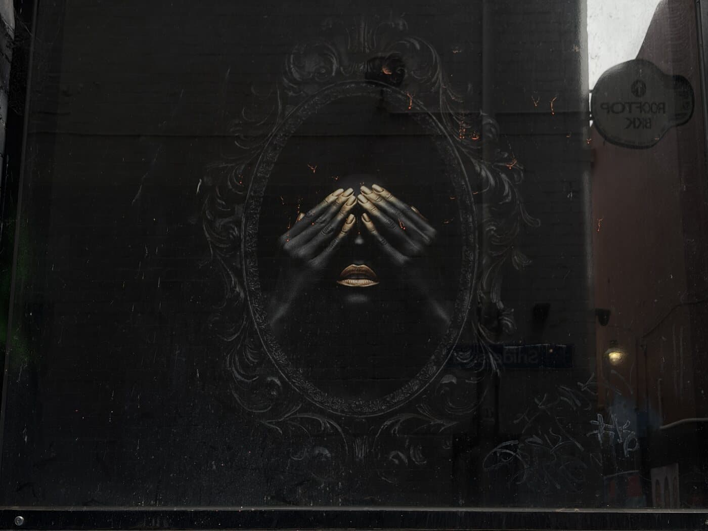 Dark painted street-art mural on a shopfront in a Melbourne CBD laneway, a subject on the Fujifilm photography course walk
