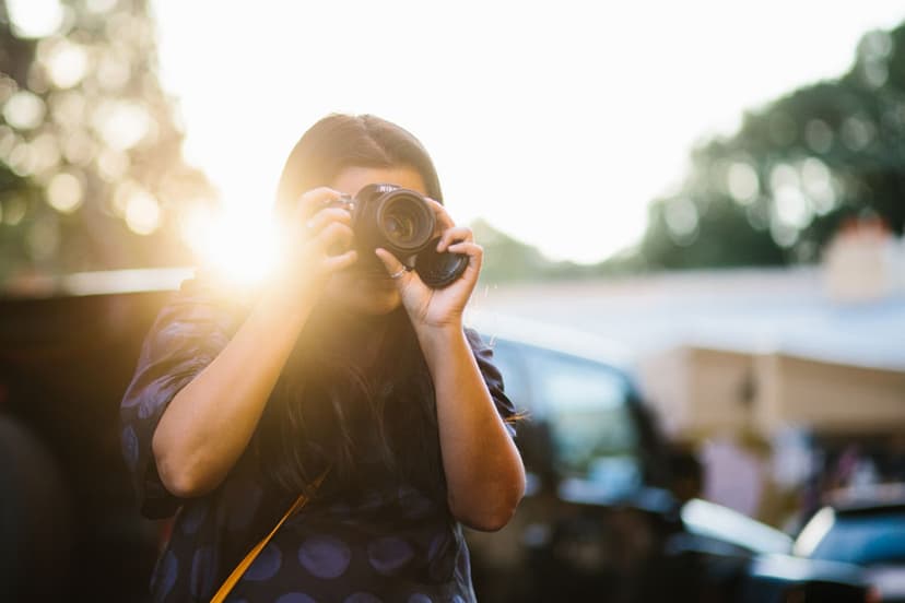 student on a camera course melbourne australia. sunset is behind her and she's holding a dslr